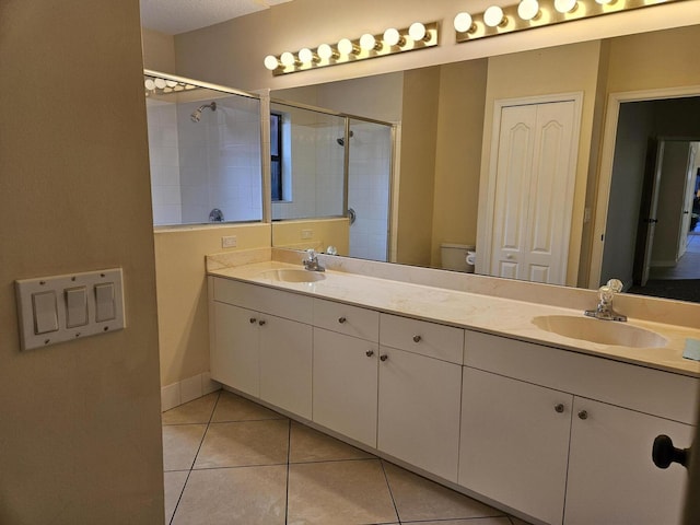 full bathroom featuring a stall shower, a closet, a sink, and toilet