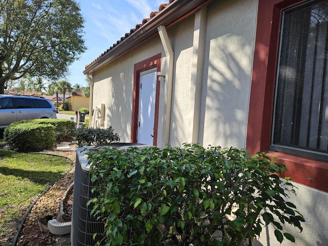 view of side of home featuring a tiled roof and stucco siding