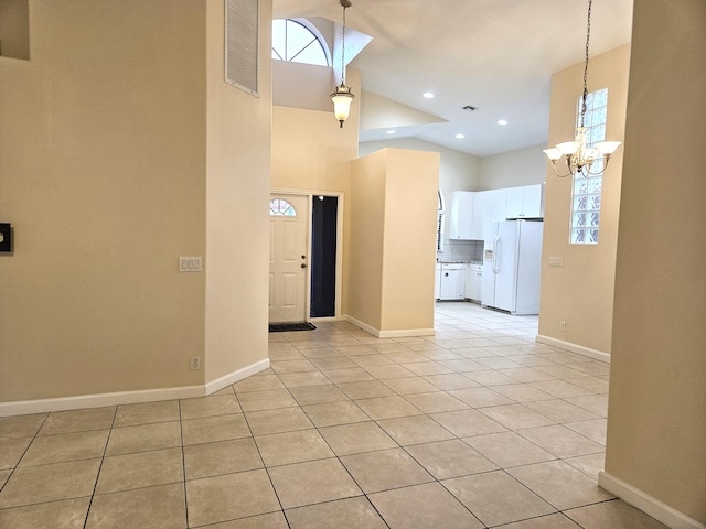 interior space featuring a chandelier, light tile patterned floors, and high vaulted ceiling