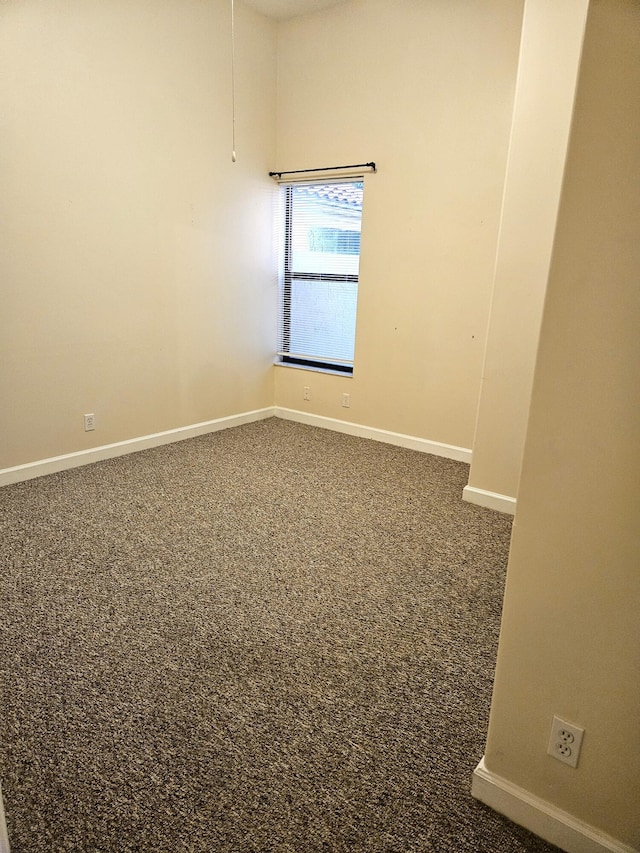 carpeted empty room with baseboards