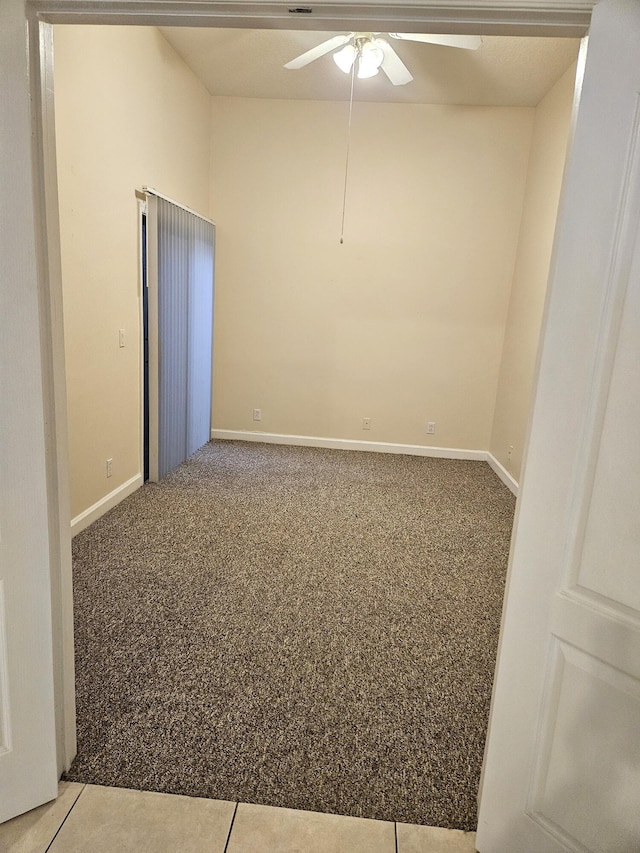 spare room with carpet, baseboards, and a ceiling fan