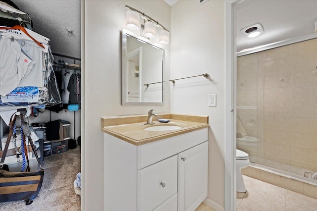 bathroom with toilet, tile patterned floors, a shower with door, a textured ceiling, and vanity