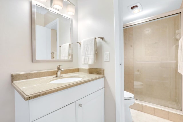 bathroom featuring tile patterned flooring, vanity, toilet, and an enclosed shower