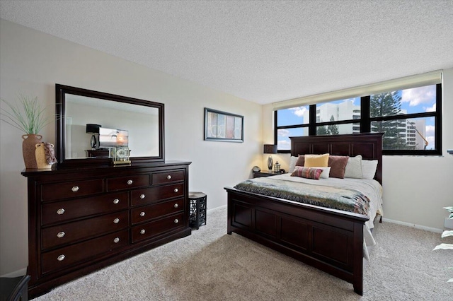 bedroom featuring light carpet and a textured ceiling