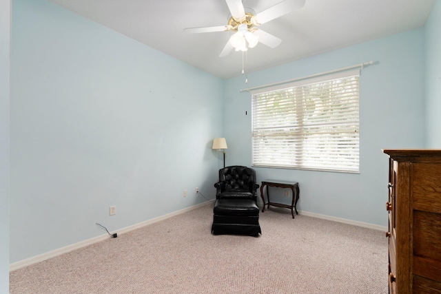 living area with light carpet and ceiling fan