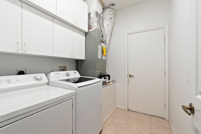 washroom featuring cabinets, light tile patterned flooring, and washing machine and dryer