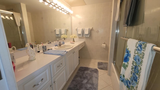 bathroom featuring vanity, tile floors, enclosed tub / shower combo, and tile walls