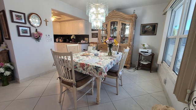 dining space featuring an inviting chandelier and light tile flooring