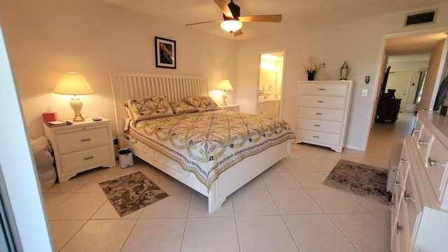 bedroom with ceiling fan, light tile floors, and connected bathroom