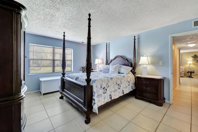 bedroom featuring a textured ceiling and light tile patterned floors