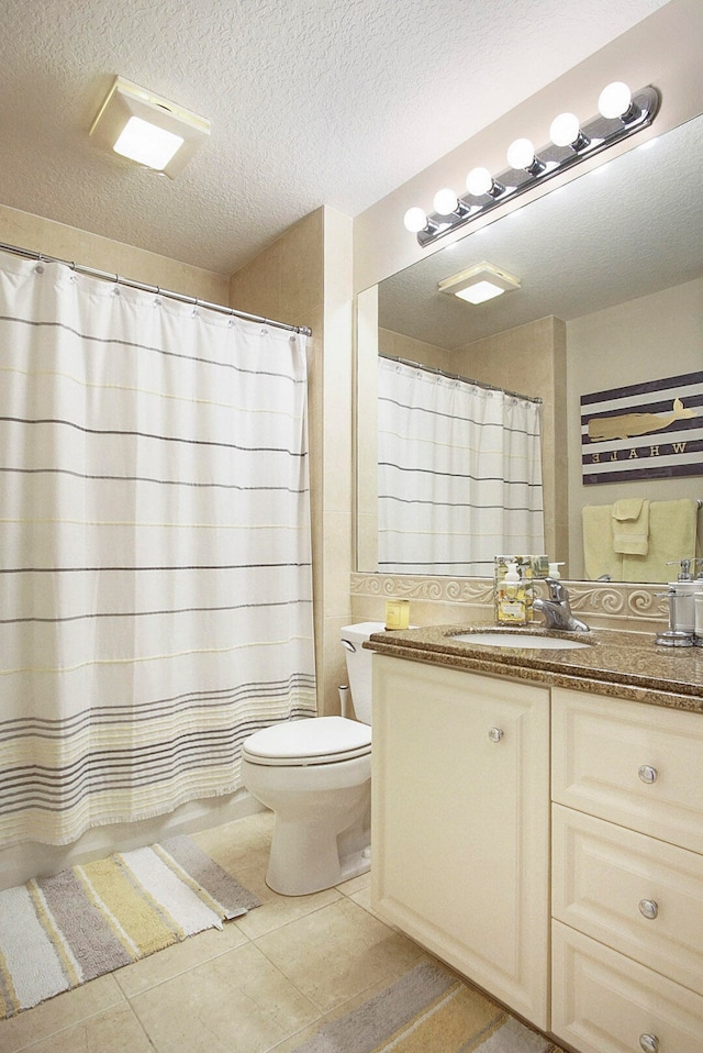 bathroom with vanity, a textured ceiling, tile patterned floors, toilet, and a shower with shower curtain