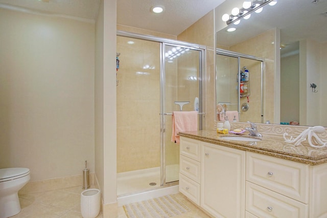 bathroom featuring a shower with shower door, vanity, a textured ceiling, tile patterned flooring, and toilet