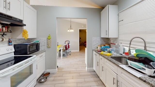 kitchen with white electric range, pendant lighting, light stone countertops, tasteful backsplash, and white cabinets