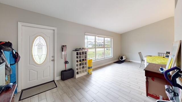 foyer featuring vaulted ceiling and light wood-type flooring