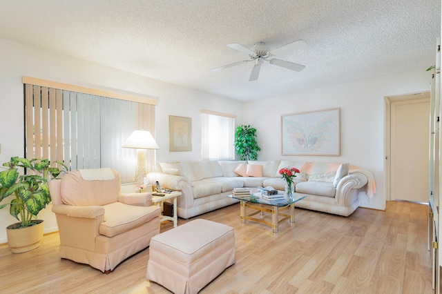 living room featuring a textured ceiling, ceiling fan, and light hardwood / wood-style flooring