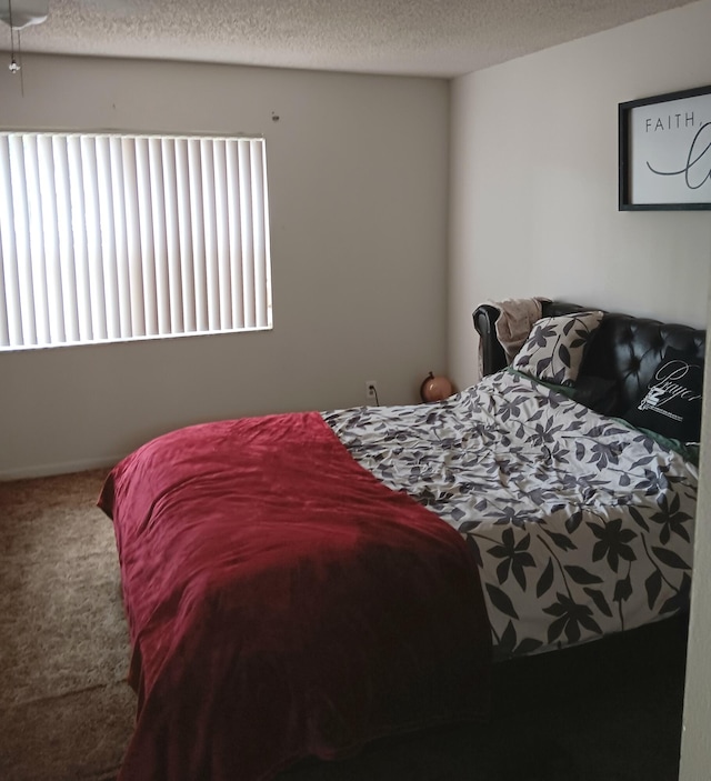 bedroom with carpet floors and a textured ceiling