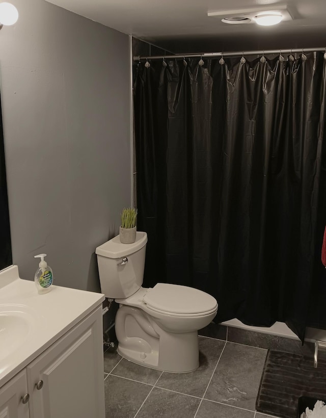 bathroom with tile floors, vanity, and toilet