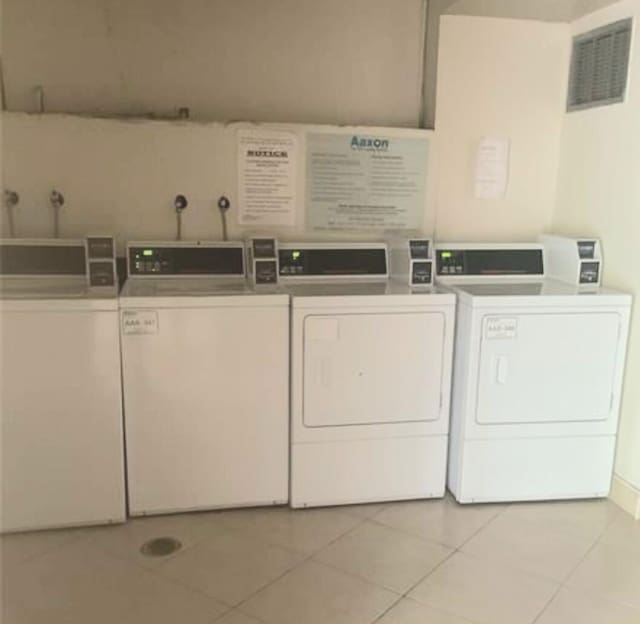 laundry area featuring washer hookup, light tile floors, and washer and clothes dryer