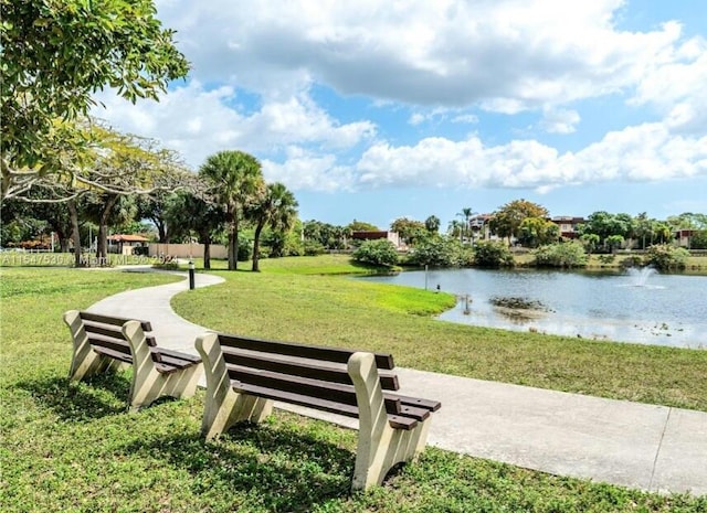 surrounding community featuring a water view and a lawn