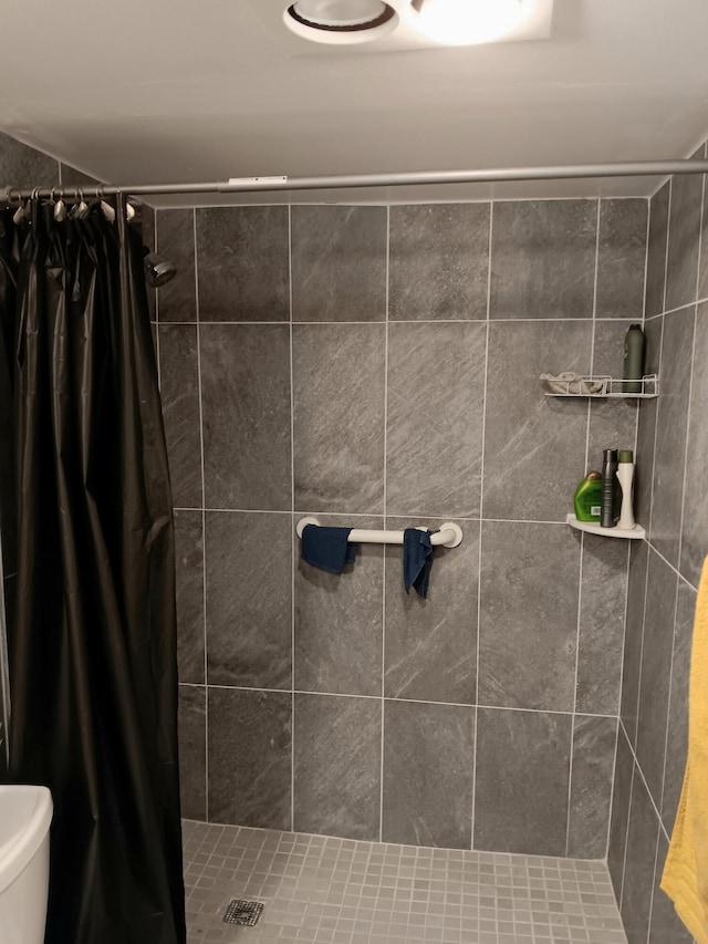 bathroom featuring a shower with shower curtain and toilet