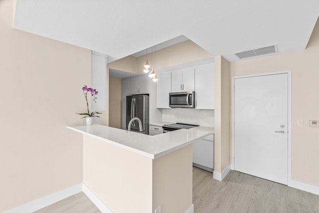 kitchen with white cabinetry, light hardwood / wood-style floors, pendant lighting, and stainless steel appliances