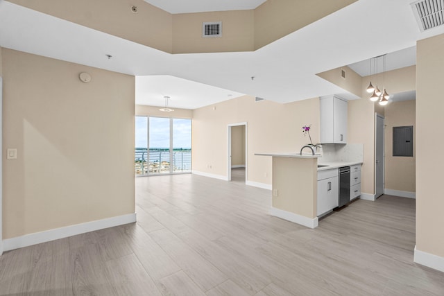 kitchen with kitchen peninsula, hanging light fixtures, white cabinets, tasteful backsplash, and a notable chandelier