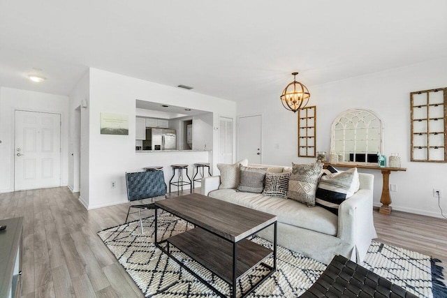 living room featuring an inviting chandelier and light hardwood / wood-style floors