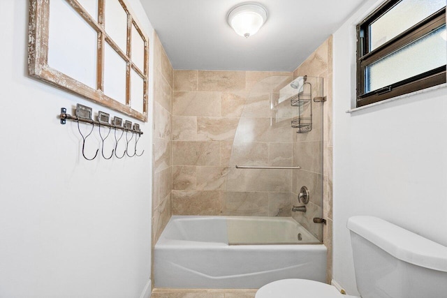 bathroom featuring toilet and tiled shower / bath