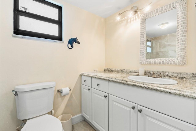 bathroom with toilet and vanity with extensive cabinet space