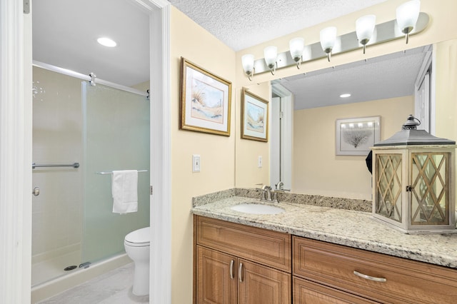 bathroom featuring toilet, a textured ceiling, vanity, tile flooring, and an enclosed shower