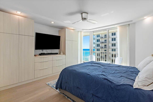 bedroom featuring floor to ceiling windows, access to exterior, light hardwood / wood-style floors, and ceiling fan