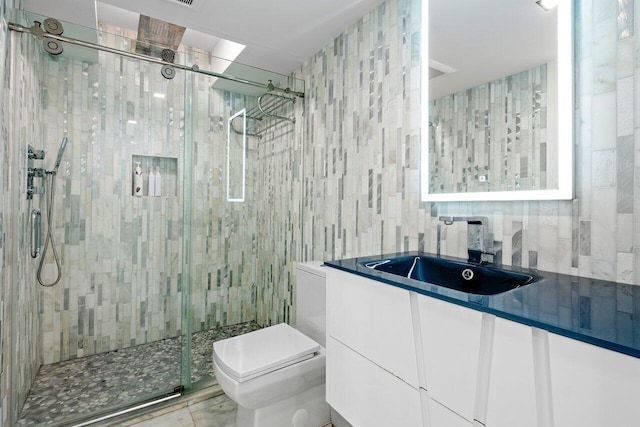 bathroom featuring tile patterned flooring, vanity, a shower with shower door, and toilet