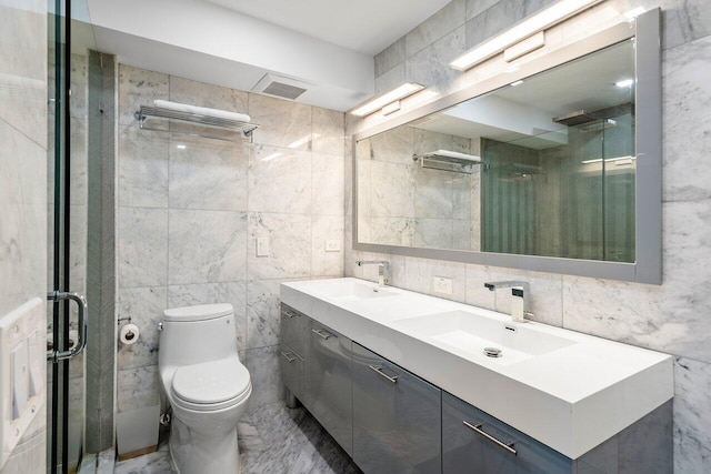 bathroom featuring vanity, a shower with shower door, tile walls, and toilet