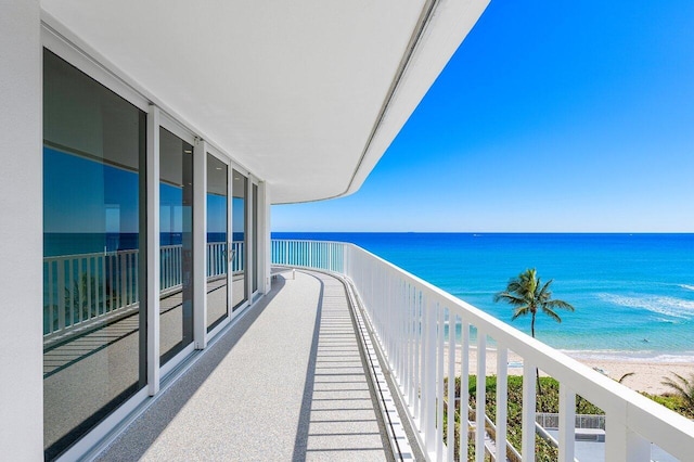 balcony featuring a beach view and a water view