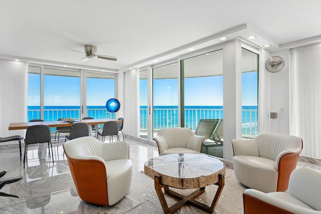 living room featuring a water view, floor to ceiling windows, and ceiling fan