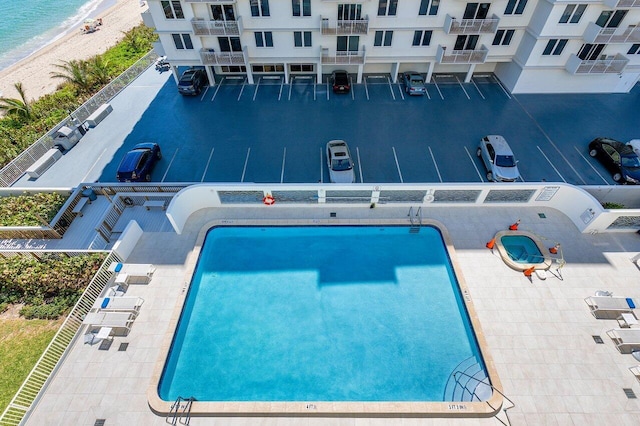 view of swimming pool featuring a water view and a beach view