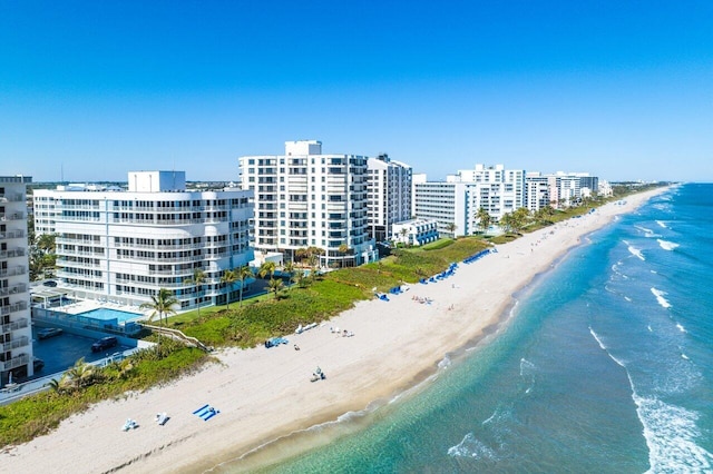 drone / aerial view featuring a water view and a view of the beach