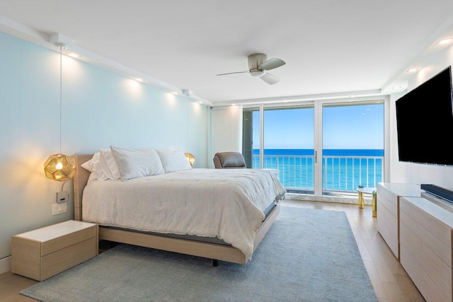 bedroom featuring ceiling fan, floor to ceiling windows, access to outside, and light hardwood / wood-style flooring