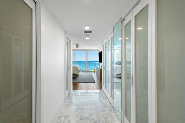 corridor with french doors and floor to ceiling windows