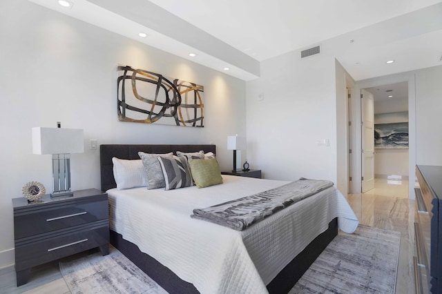 bedroom featuring ensuite bathroom and light hardwood / wood-style floors