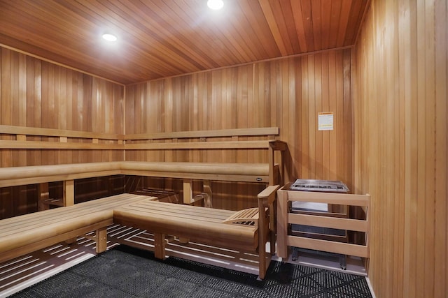 view of sauna with wooden ceiling and wooden walls