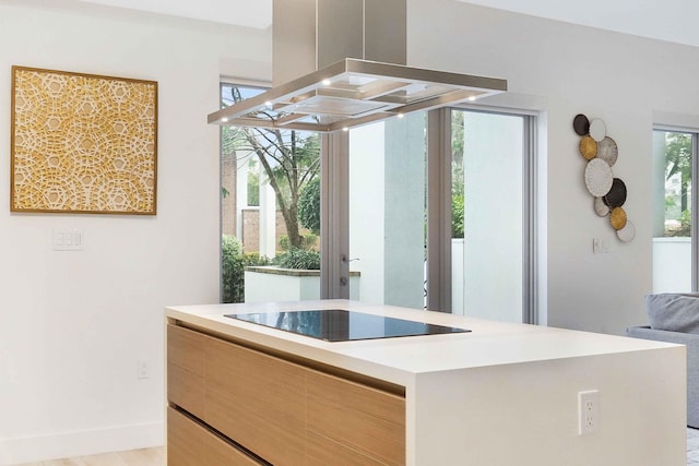 interior space with island exhaust hood, light wood-type flooring, and black electric stovetop