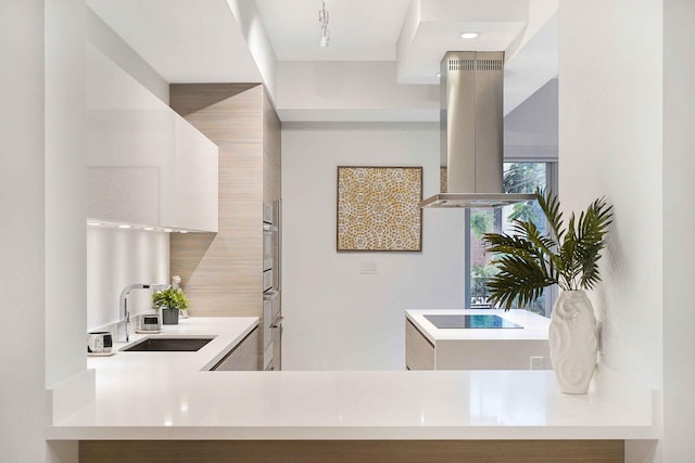 kitchen with sink, island exhaust hood, black electric cooktop, stainless steel oven, and decorative backsplash