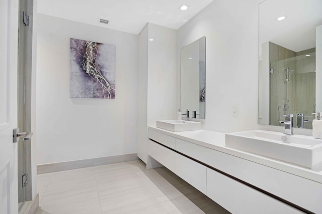 bathroom with tile patterned flooring, a shower with shower door, and vanity