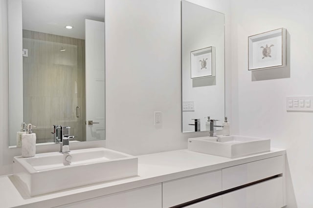 bathroom with a shower with door and vanity