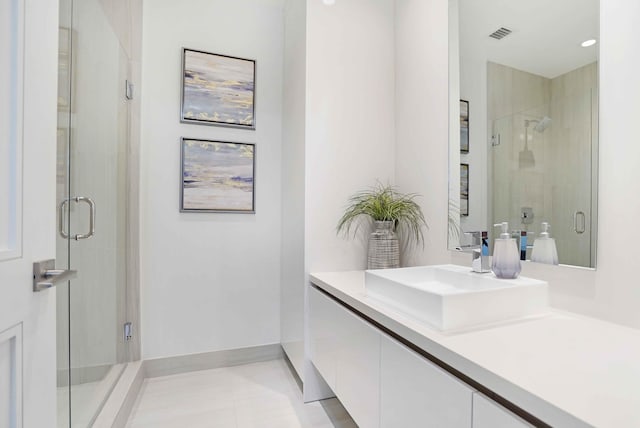 bathroom featuring vanity, a shower with door, and tile patterned floors