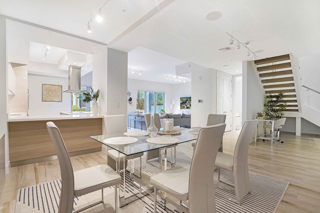 dining room featuring light wood-type flooring and track lighting