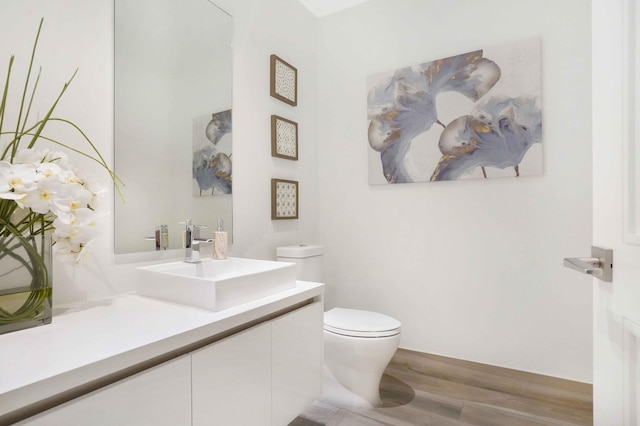 bathroom featuring hardwood / wood-style flooring, vanity, and toilet