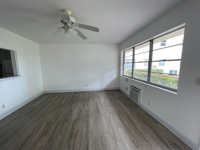 empty room featuring a textured ceiling, a wall mounted AC, ceiling fan, and dark hardwood / wood-style floors