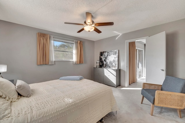 bedroom featuring light carpet, ceiling fan, and a textured ceiling